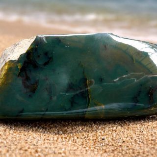 зеленый янтарь на песчанном пляже